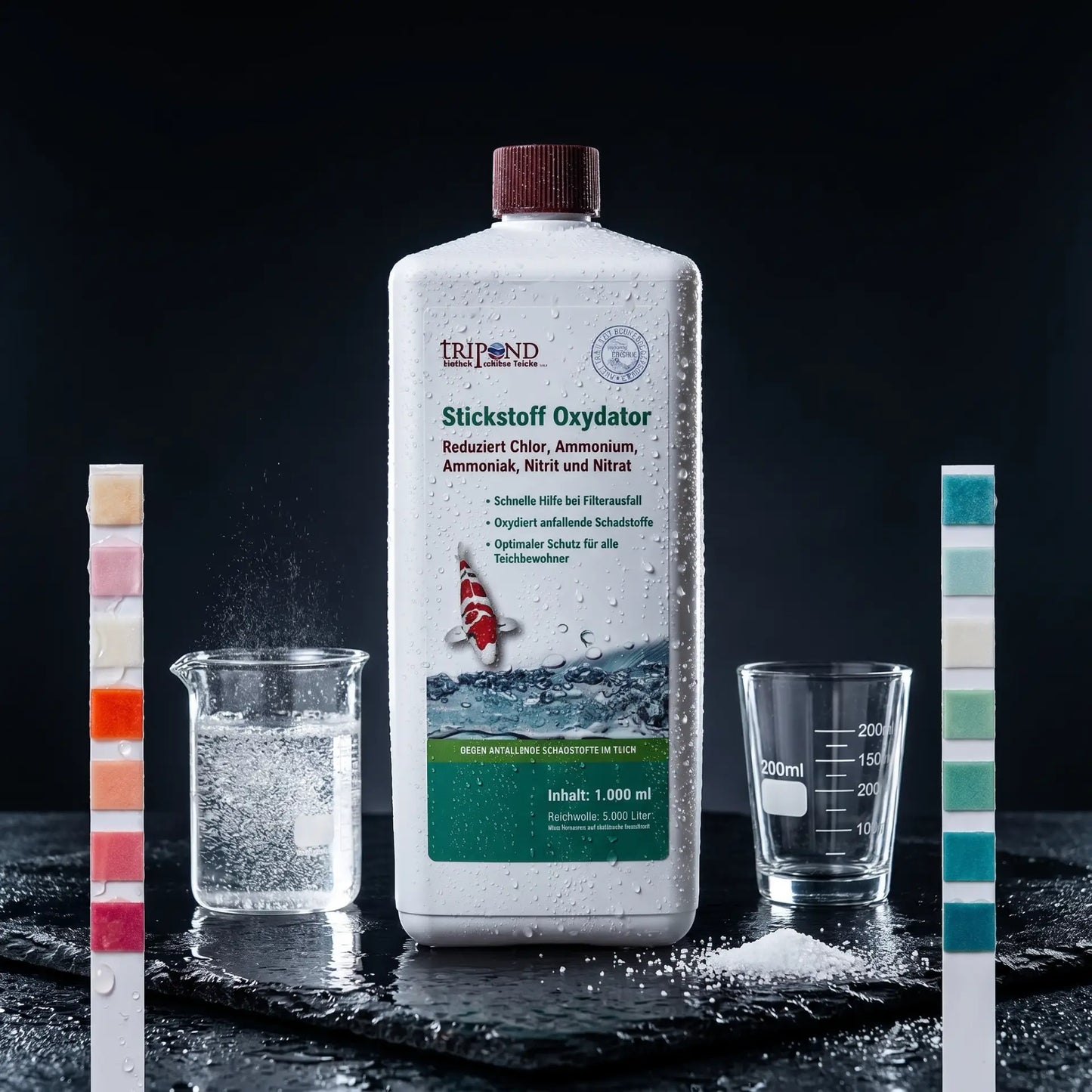 Tripond Stickstoff Oxydator auf schwarzem Naturschiefer – roter Gefahren-Teststreifen links, Oxidationsreaktion im Glasröhrchen, grüner Sicherheits-Teststreifen rechts – Notfallmittel gegen Ammonium, Nitrit und Chlor im Koiteich, sofortige Wirkung in 30-60 Minuten